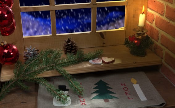 Close up of a window, decoration christmas,  candle and snow outside.