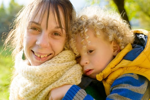 a little blond boy and his mom play outside, an autumn day