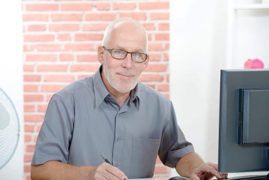 Senior businessman working on computer in his office