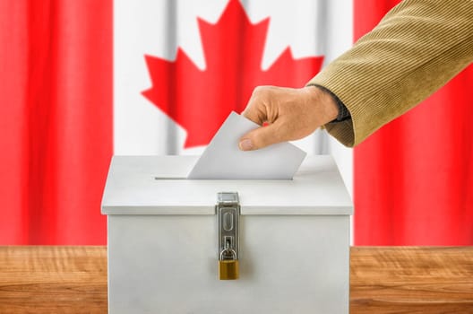 Man throws ballot papers into ballot box - Canada