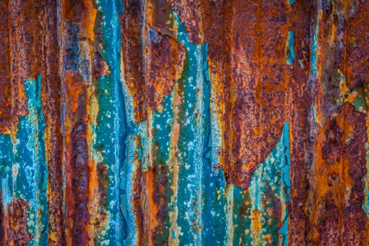 Rusty wall surface with blue paint and nails