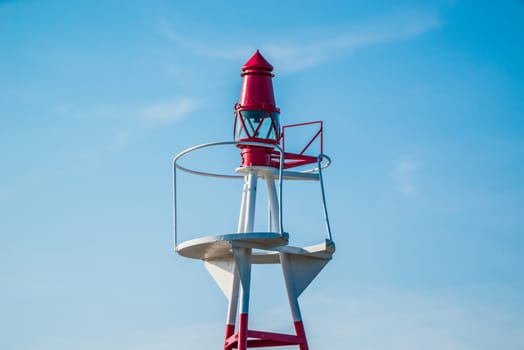 Small lighthouse on blue sky in daylight