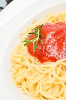 Delicious spaghetti with tomato sauce and a rosemary twig