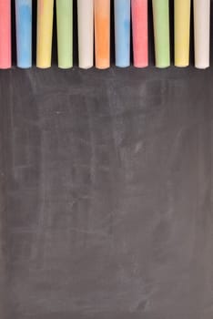 Colorful chalk on a blackboard with space for text or image