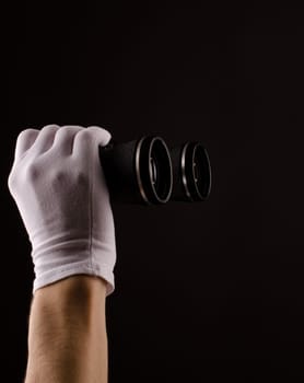 Male hands with white gloves holding binoculars