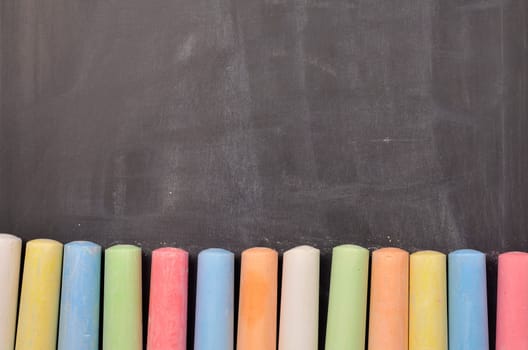 Colorful chalk on a blackboard with space for text or image