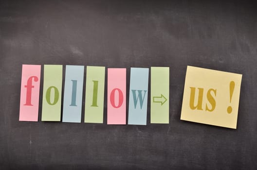 Blackboard with colourful sticky notes with the words follow us!