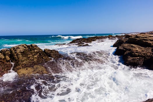 Ocean wave crashing rocky shoreline exploding white water power