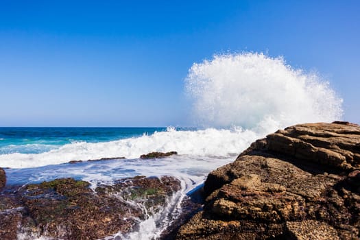 Ocean wave crashing rocky shoreline exploding white water power
