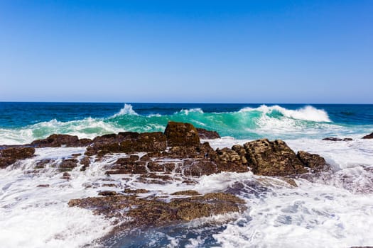 Ocean wave crashing rocky shoreline exploding white water power