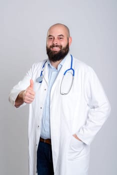 young bearded doctor in white coat and thumb up