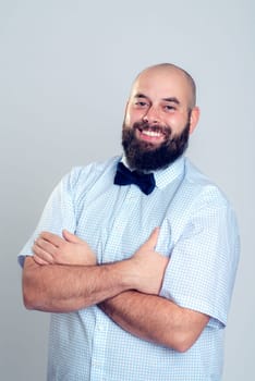 young smiling and bearded man in blue shirt and bow tie