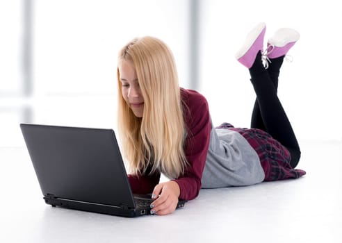 nice blond girl with laptop lying on the floor