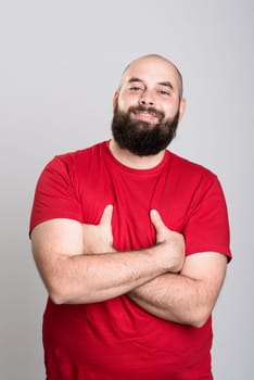 young bearded man in red shirt and crossed arms