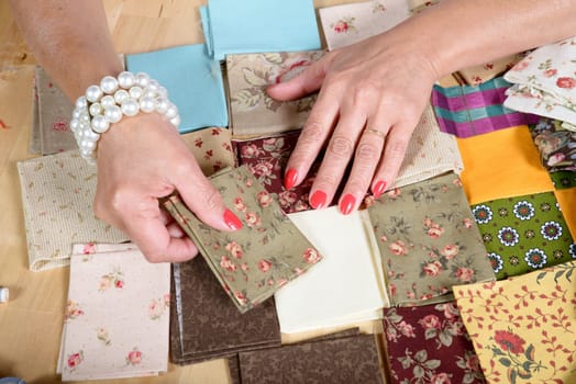 Close up of woman's hand sewing patchwork