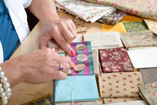 Close up of woman's hand sewing patchwork