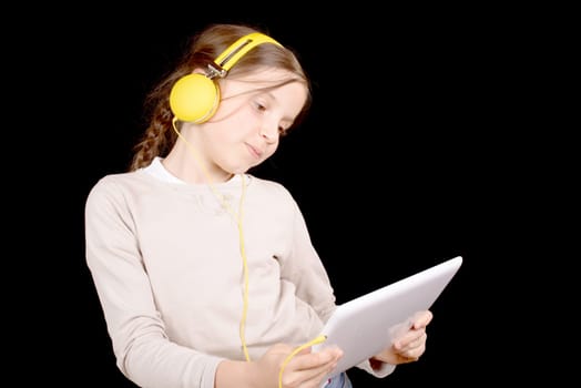 a young girl with yellow headphones and a digital tablet