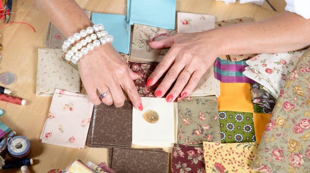 Close up of woman's hand sewing patchwork