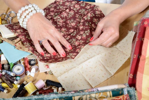 Close up of woman's hand sewing patchwork
