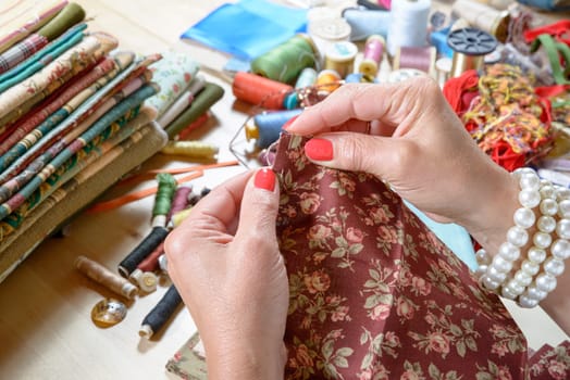 Close up of woman's hand sewing patchwork