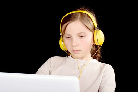 a young girl with yellow headphones and a digital tablet
