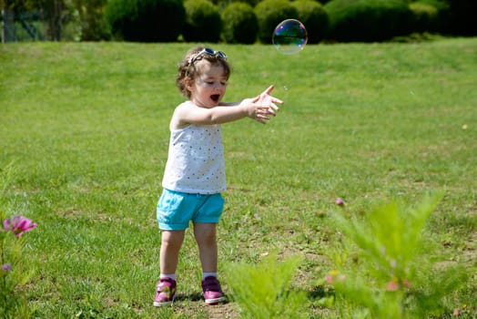 a little girl playing with soap bubbles