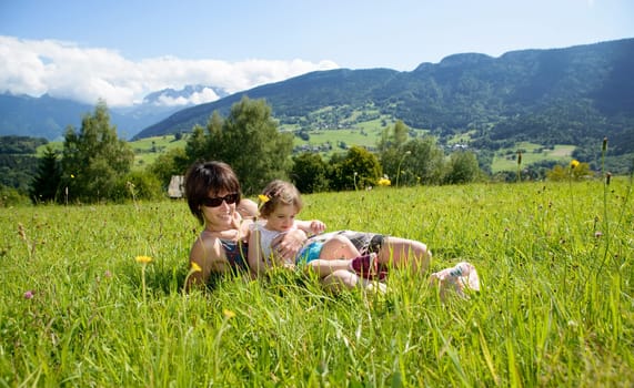 a beautiful mother and daughter lying on the grass