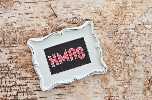 Table with vintage frame on rustic bark
