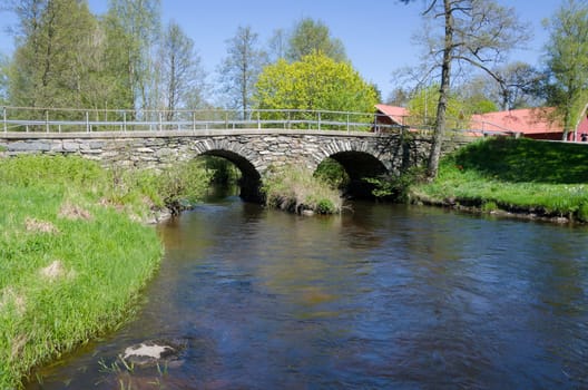 the dark water is running under the old bridge made of stone