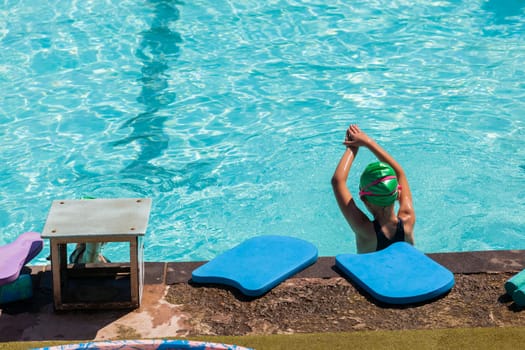 Young girl looks length of swimming pool lessons learning to swim challenges goals