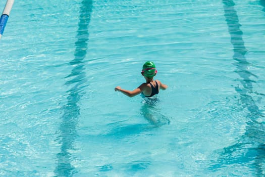 Young girl looks length of swimming pool lessons learning to swim challenges goals