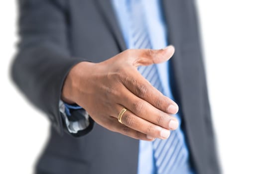 Close up Indian businessman hand offering handshake, standing on plain background.