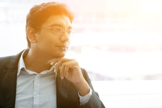 Asian Indian business man waiting his flight at airport on a beautiful golden sunset day.