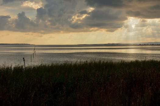 Sunset in the lagoon, where fishermen return to the approach of the impending storm. Dawning. Mediterranean islands.