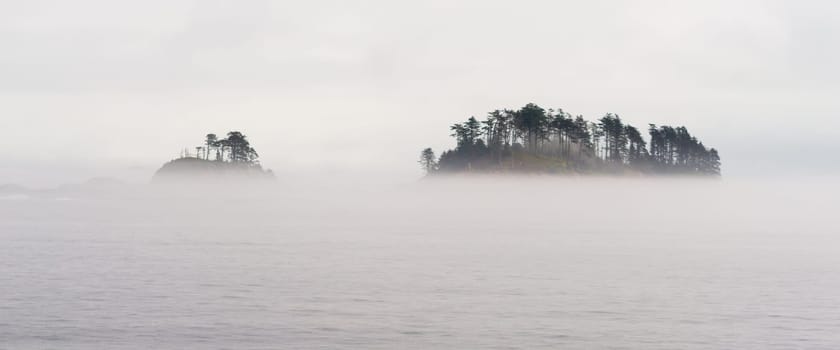 Fog surrounds a small island in the inside passage