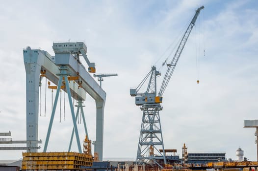 Various types of cranes at work in a shipyard