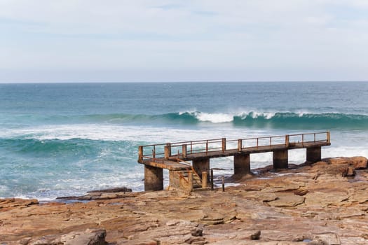 Fishing jetty pier along rocky coastline ocean landscape