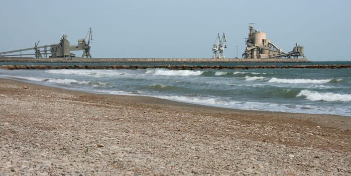 Alcanar beach with cement plant industry docks at the bottom, Tarragona, Spain