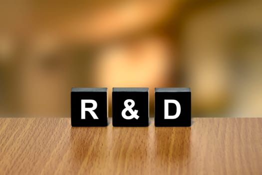 r&d or Research and development on black block with blurred background