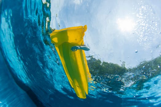 Underwater upward of girl on air-matt sunbathing swimming pool home solitude.