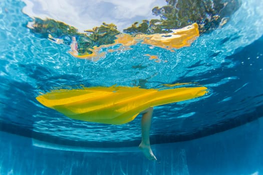 Underwater upward of girl on air-matt sunbathing swimming pool home solitude.