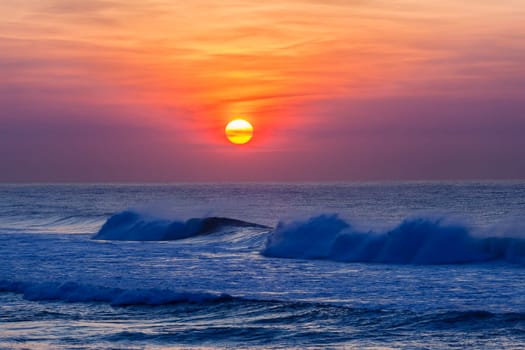 Beach ocean waves with sunrise on horizon water