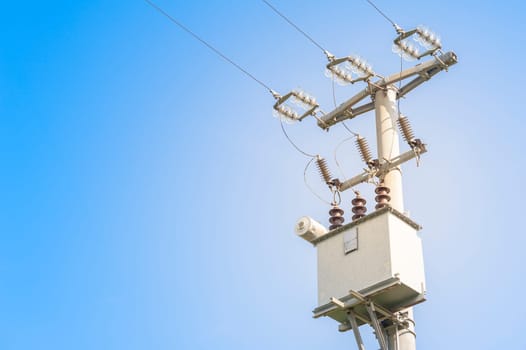 Electrical transformer of electrical pylon against the blue sky