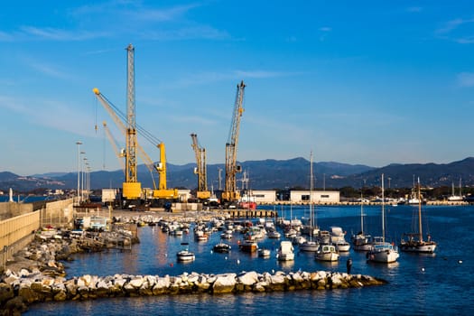 Panoramic view of a commercial port in a sunny morning with mountains in the background