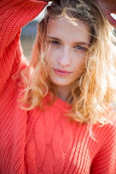 Portrait of a beautiful young woman at the beach. She is looking at the camera and wearing casual clothing.