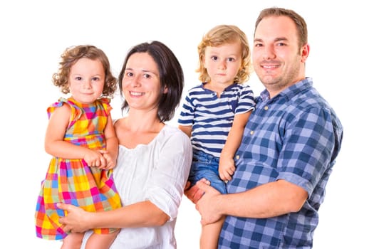 Happy family of four smiling while standing against white background.