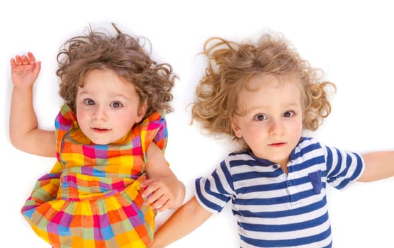 Little boy and girl looking at camera on white background.