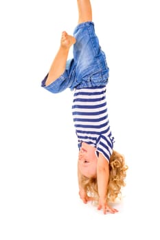 Happy little boy upside down on white background.