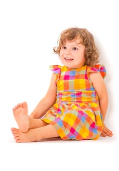 Cute little girl sitting on the floor and smiling on white background.