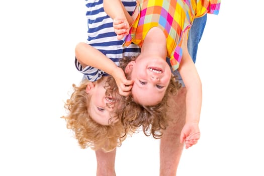 Father hands holding his smiling and playful children upside down on white background.